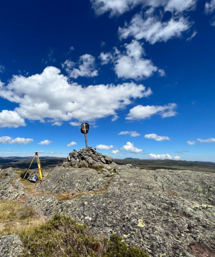 Survey equipment and a stone cairn survey marker on a rocky outcrop on Mt Cope.