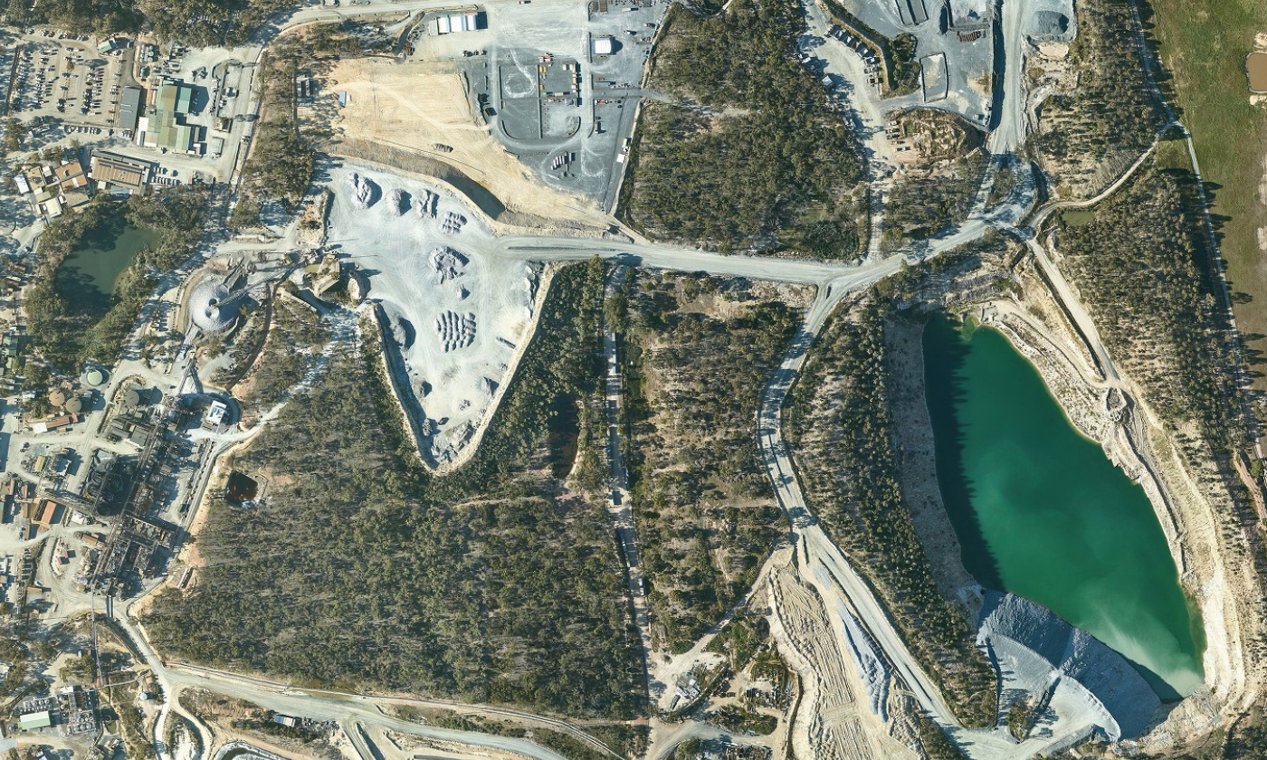 Aerial imagery in the Axedale-Moe and Golden Plains region showing an area of trees, roads, buildings and a watercourse.