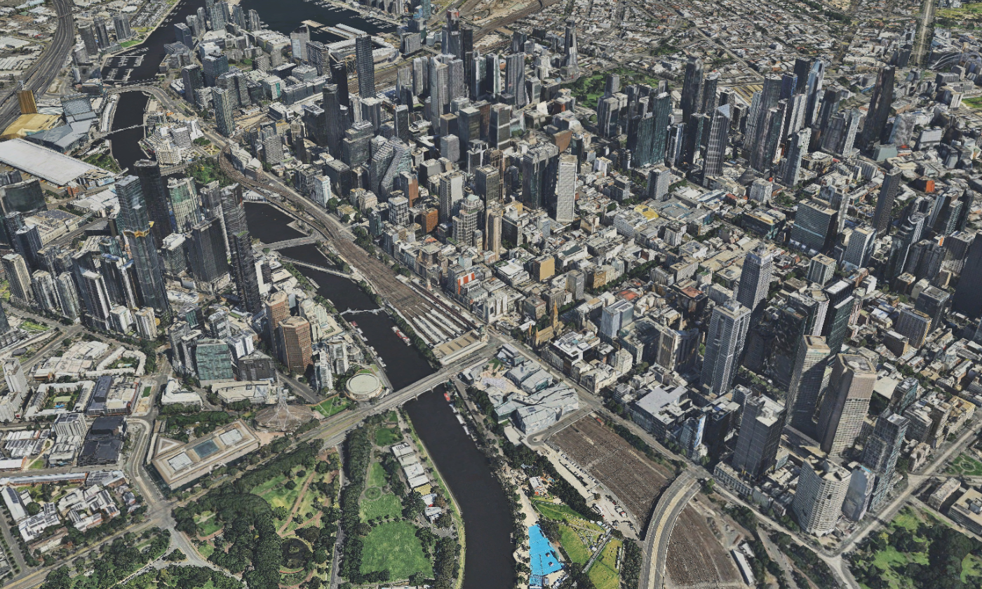 A screenshot taken within the Digital Twin Victoria platform showing a digitally constructed 3D image looking down and across the City of Melbourne, with Flinders Street station in the foreground and the edges of Port Melbourne in the background.