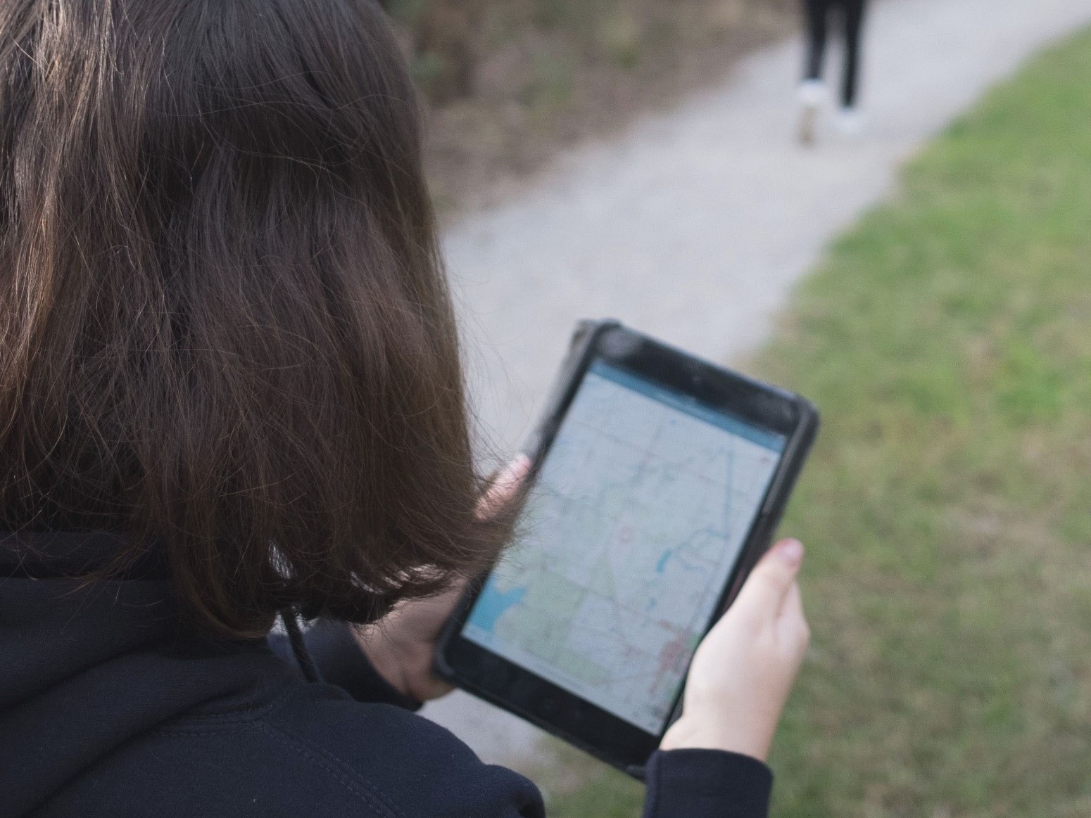 Person using the Vicmap Viewer app on a tablet device on a walking track.