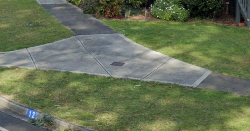 Photo of a metal survey mark within a concrete footpath.  